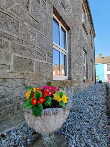 a stone flower pot sitting in front of a building at Clonbur House - Studio village apartment in Galway