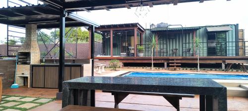 a patio with a swimming pool and a house at Casa Container in Santa Rita do Passa Quatro