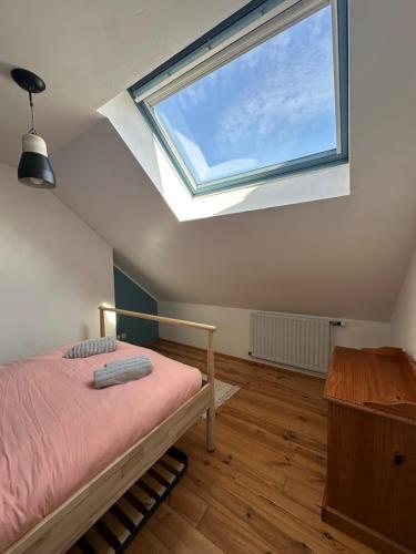 - une chambre avec un lit doté d'une lucarne et d'une fenêtre dans l'établissement La Malouine Dunkerquoise HomyNest, à Dunkerque