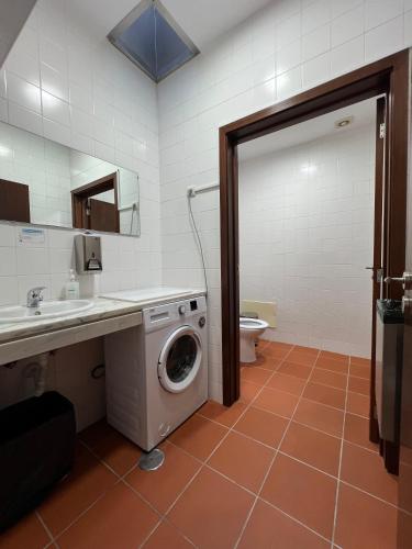 a bathroom with a washing machine and a toilet at Casa da Cabração - Refúgio de Natureza e Sossego in Ponte de Lima