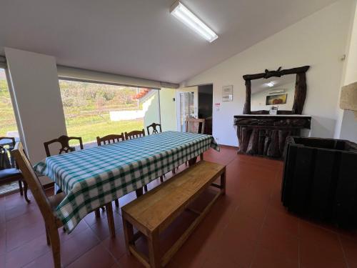 a room with a table and a bench and a mirror at Casa da Cabração - Circuito Aldeias de Portugal in Ponte de Lima