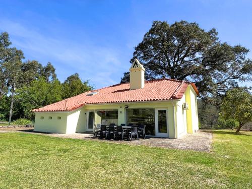 a small white building with black tables and chairs at Casa da Cabração - Refúgio de Natureza e Sossego in Ponte de Lima