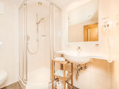 bagno bianco con lavandino e doccia di Farm Resort Geislerhof a Gerlos