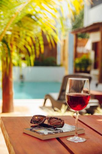 a glass of wine and a pair of glasses on a table at Shankara Holbox in Holbox Island