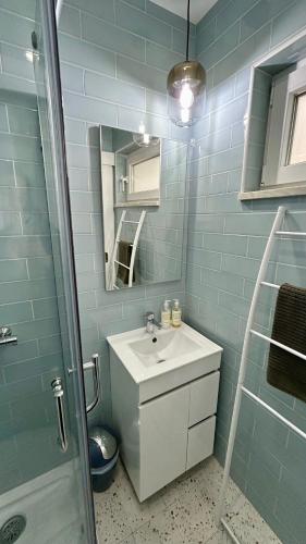 a bathroom with a sink and a mirror and a shower at Casa Berlenga in Peniche