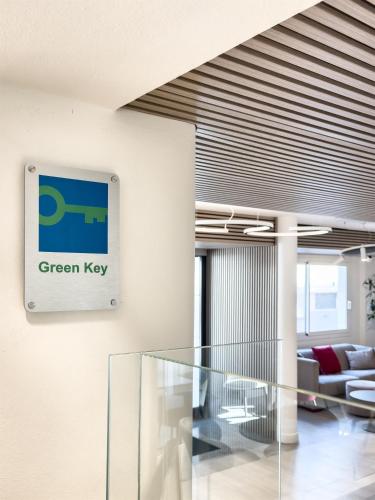 a lobby with a green key sign on the wall at Best Western Hotel Residence Italia in Quartu SantʼElena