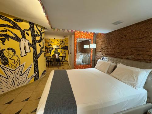 a bedroom with a white bed and a mural at Shop Motel in Campina Grande