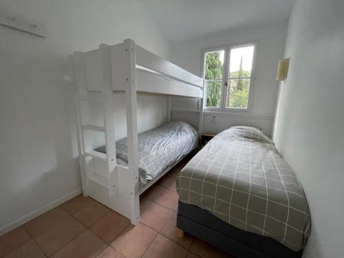 une chambre avec deux lits superposés et une fenêtre dans l'établissement Maison Grimaud, à Grimaud