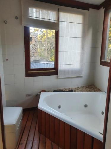 a bathroom with a bath tub and a window at PiedrasBlancas in Mar de las Pampas