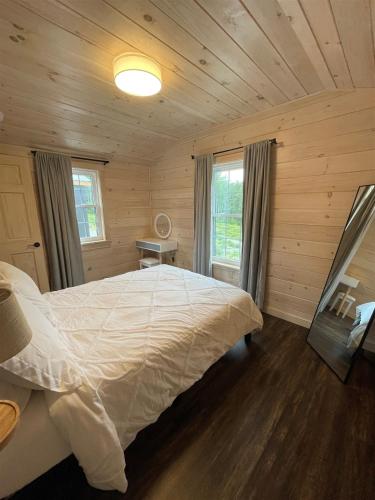 a bedroom with a large bed in a wooden room at WOOD THRUSH LIMIT 3 cabin in North Sebago
