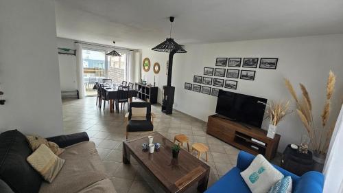 a living room with a couch and a tv at Maison de la plage Vendée Notre-Dame-de-Monts 700m de la mer in Notre-Dame-de-Monts
