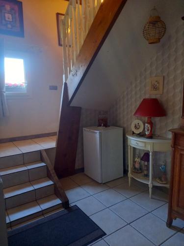 a room with a staircase and a small refrigerator at Gîte La MER in Commes