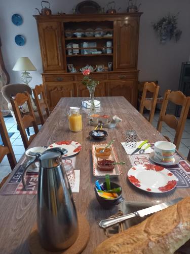 a wooden table with plates and a tea kettle on it at Gîte La MER in Commes