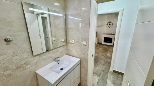 ein weißes Badezimmer mit Waschbecken und Spiegel in der Unterkunft Escapada de Relax y Diseño con Piscina y Barbacoa in Torremolinos