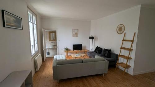 un salon avec un canapé et une table dans l'établissement Maison Vacances La Rochelle, à La Rochelle