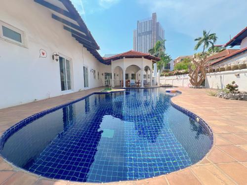 a swimming pool with blue tiles in a house at Gary Pool Villa Pattya in Pattaya South