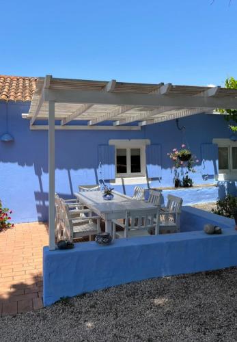 a patio with a table and chairs under a pergola at Quintal Alentejano in Fataca