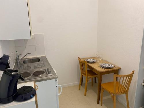 a small kitchen with a small table and a table and chairs at La Parenthèse - Ideal couple - Lumineux et central in Bar-sur-Aube