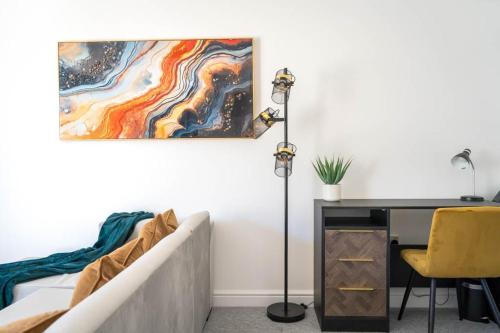 a bedroom with a desk and a bed and a painting at N E W - Boutique Apartment in Isle of Wight