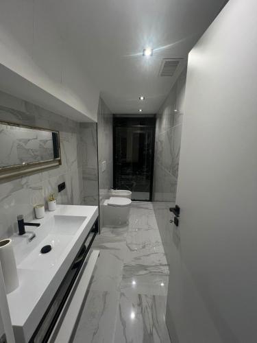 a white bathroom with a sink and a toilet at Vale House Apartment near Rho Fair in Baranzate