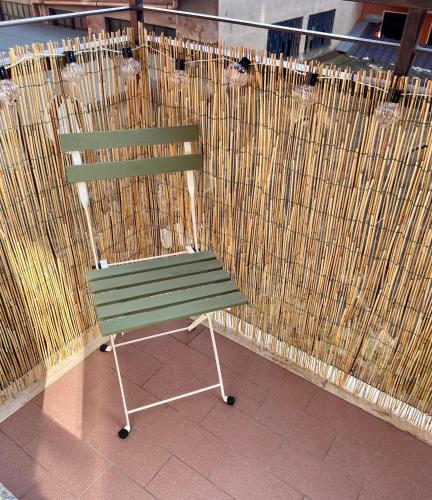 a green bench sitting in front of a fence at Vale House Apartment near Rho Fair in Baranzate
