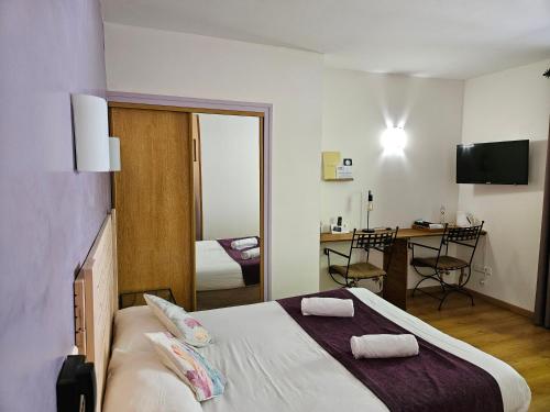 a bedroom with a bed with two towels on it at Hôtel Le Mont Barral in Creyers