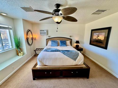 Un dormitorio con una cama con ventilador de techo. en Epic Views, Huge House, Acres of J-Trees to explore, Hot Tub, Pool, AC, and Mini-Golf, en Joshua Tree