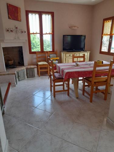 - un salon avec une table, des chaises et une télévision dans l'établissement Casa Ghjuvanna, à Galéria