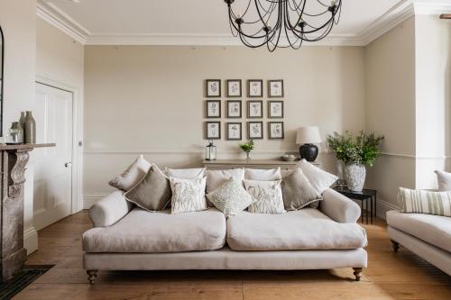 a living room with a couch and a chandelier at Sutton Hall, Norfolk in Hickling