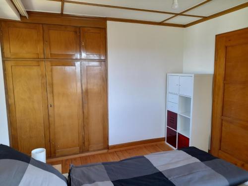 Schlafzimmer mit Holzschränken, einem Bett und einem Schrank in der Unterkunft Ferienwohnung Unterm Tulpenbaum in Müllheim