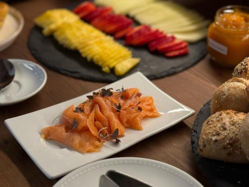 a wooden table with plates of food on it at Quinta da Amendoeira - Évora - The Farmhouse in Évora