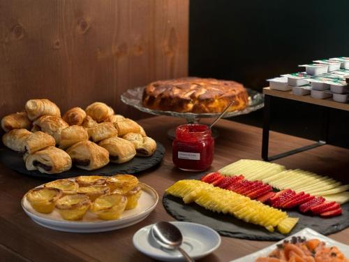 a table topped with different types of bread and pastries at Quinta da Amendoeira - Évora - The Farmhouse in Évora