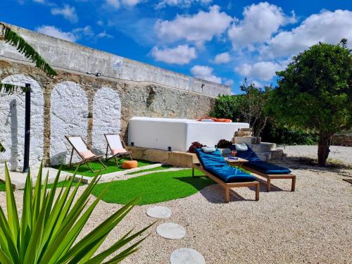a patio with two chairs and a tub in front of a building at Pool oasis with private parking -Vigia 8 in Torres Vedras