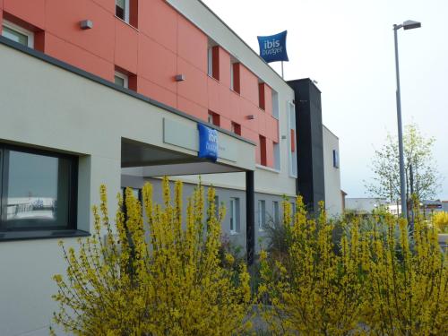 a building with yellow plants in front of it at Ibis Budget Roanne Hôtel in Roanne