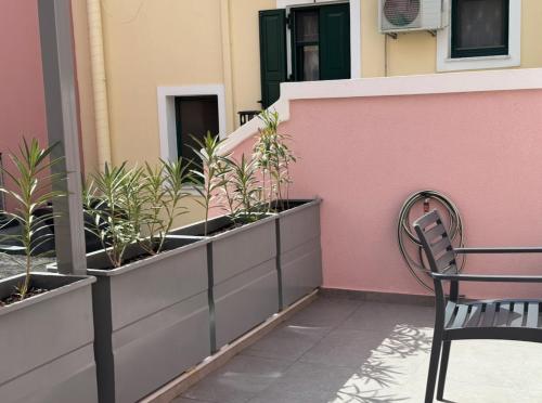 a bench sitting on a balcony with plants at Iris Luxury Loft in Mytilini