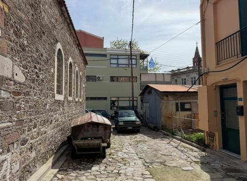 an alley with a car parked next to a building at Iris Luxury Loft in Mytilini
