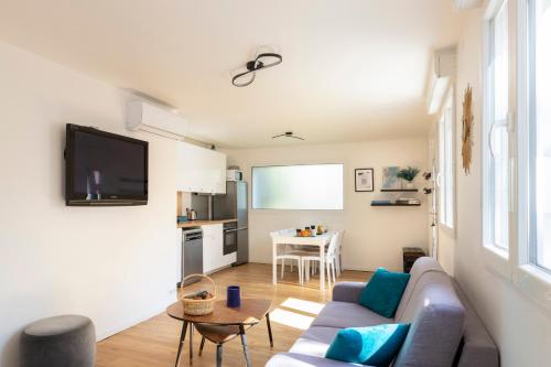 a living room with a couch and a table at La Volcane - Quiet house in Le Chesnay