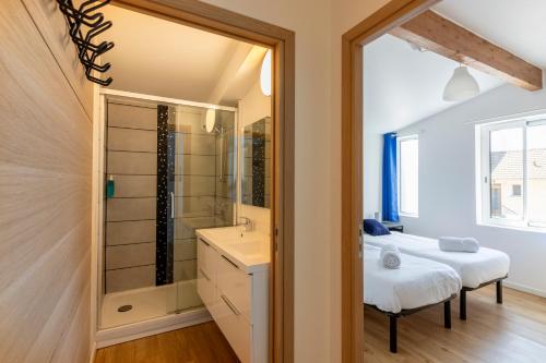 a bedroom with a bed and a shower and a sink at La Volcane - Quiet house in Le Chesnay