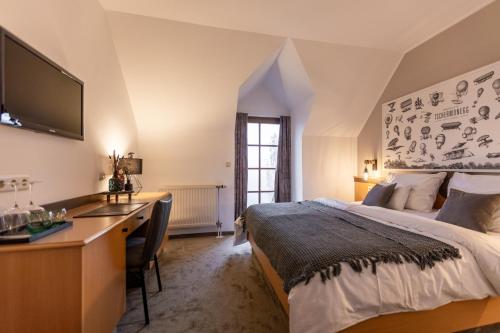 a bedroom with a bed and a desk with a computer at Wohnen beim Wein Tschermonegg in Sulz