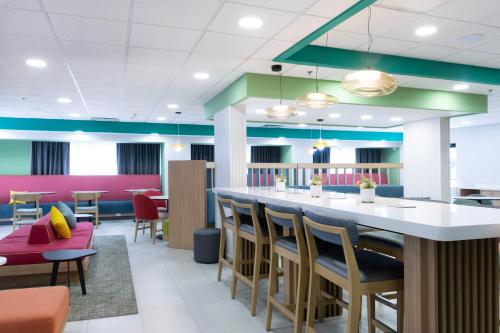 a restaurant with a bar with chairs and tables at Hampton by Hilton Saltillo Zona Aeropuerto in Saltillo