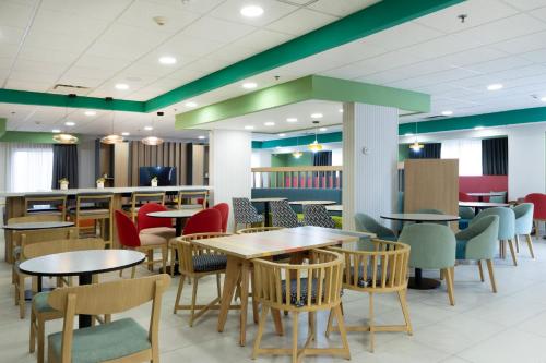 a dining area with tables and chairs in a cafeteria at Hampton by Hilton Saltillo Zona Aeropuerto in Saltillo