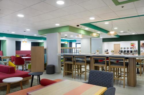 a restaurant with a bar and tables and chairs at Hampton by Hilton Saltillo Zona Aeropuerto in Saltillo