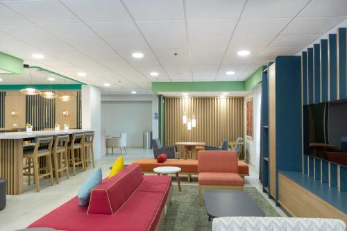 a living room with colorful furniture and a bar at Hampton by Hilton Saltillo Zona Aeropuerto in Saltillo