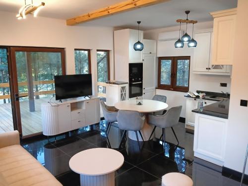 a kitchen and living room with a table and chairs at Osada Blanka Black & White Swornegacie in Swornegacie 