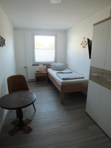 PruchtenにあるEinzelzimmer mit Gemeinschaftsbadのベッドと椅子と窓のある寝室