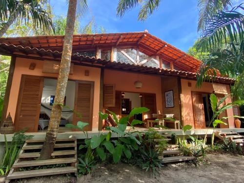 a house on the beach with palm trees at Vila Pitanga - Arandis in Marau