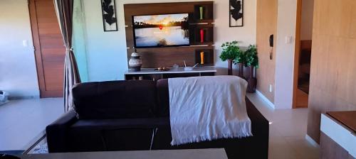 インバサイにあるResidencial Ykutiba - Imbassai - D103のソファとテレビのあるリビングルーム