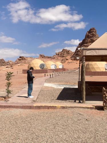 a man taking a picture of the desert at Wadi Rum Santa Camp in Wadi Rum