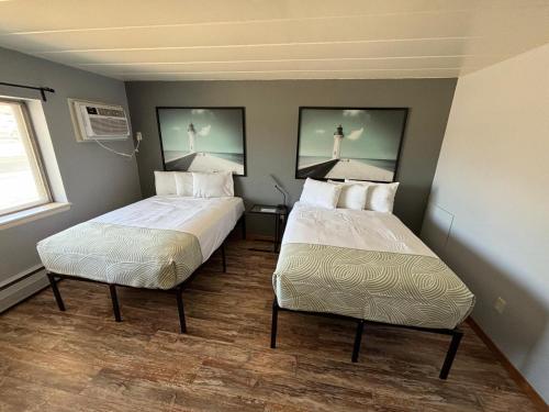 two beds in a small room with at Valued Stay Aloha in Madison