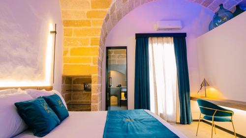 a bedroom with a bed and a chair and a window at Regina Elena Suites & Private SPA in Sannicola